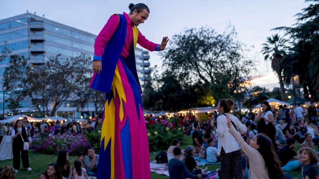 Ein Stelzenkünstler begeistert das Publikum auf einem Open-Air-Festival.