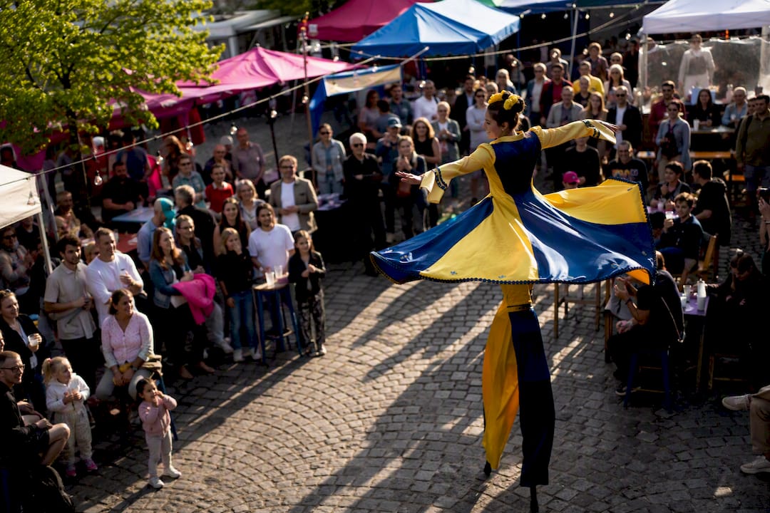 Ein Stelzenläufer tritt allein auf einem Festival auf